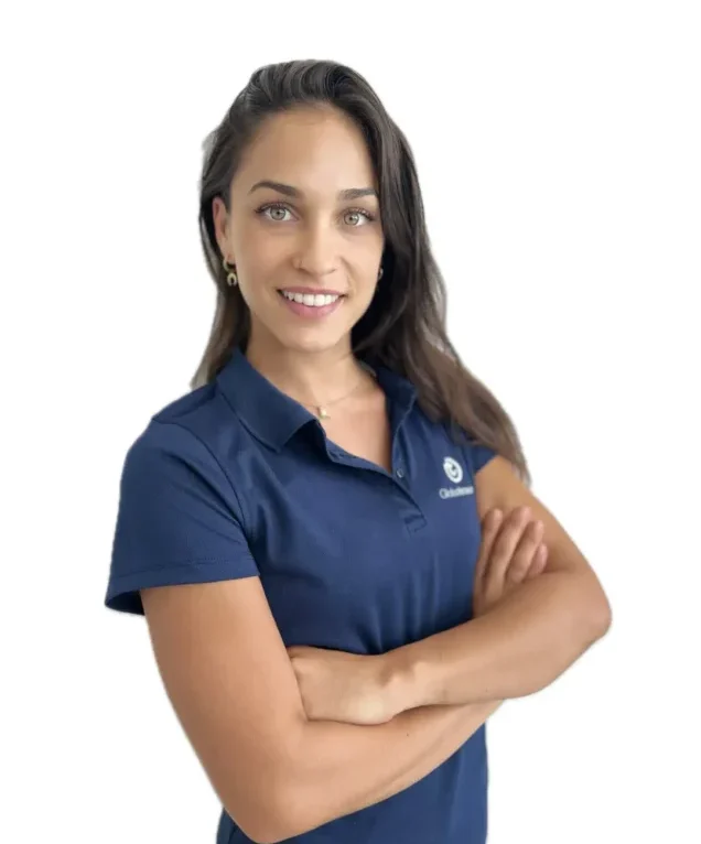 Lucía Giménez, una fisioterapeuta joven y apasionada, sonriendo mientras atiende a un paciente en una clínica moderna. Viste un uniforme profesional de color claro, con una expresión cálida y amable, que refleja su dedicación y empatía hacia sus pacientes.