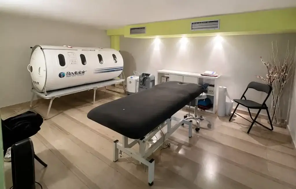 Sala de tratamiento con cápsula hiperbárica de última generación y camilla médica para sesiones de oxigenoterapia hiperbárica en Palma de Mallorca.