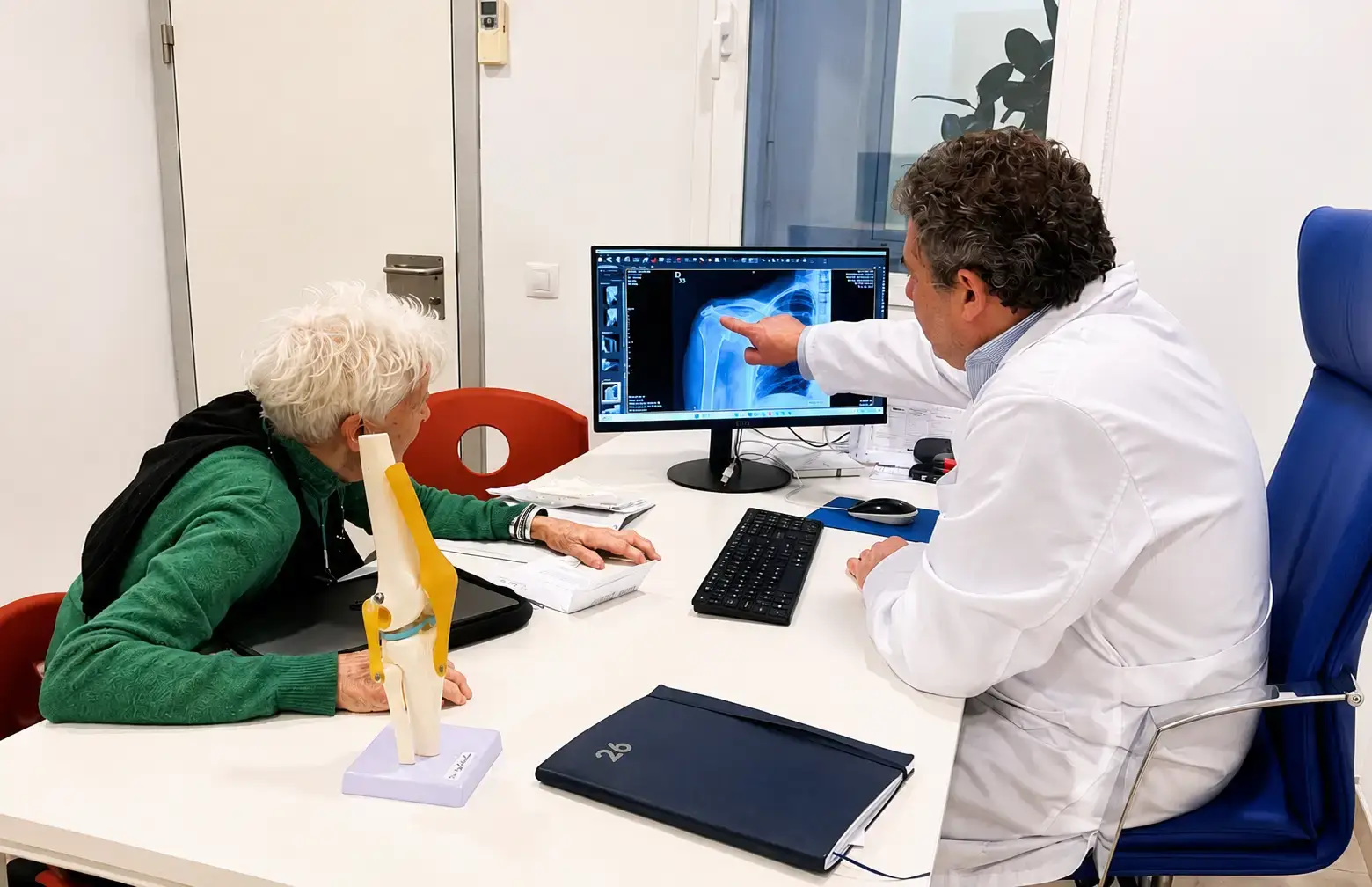 Traumatólogos ortopedistas en Mallorca realizando una consulta con análisis de radiografía de hombro en Global Clinics, Palma de Mallorca.